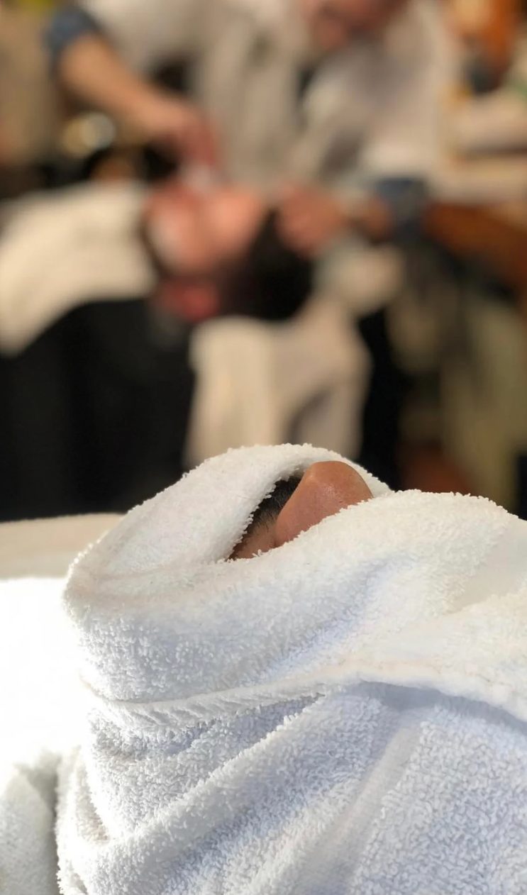 Client wrapped in a hot towel before a razor shave